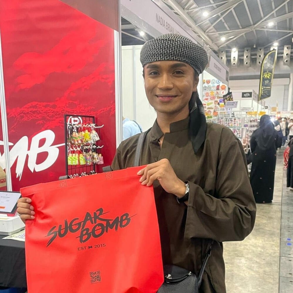 Spreading the love for SugarBomb fragrances at local lifestyle events. A satisfied shopper holding a SugarBomb SG bag, showcasing the best perfume store deals for long-lasting inspired scents in Singapore.